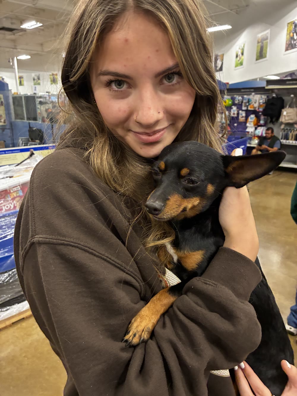 Nora holding a small black-and-tan dog